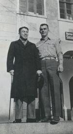 Unknown male standing next to Lawrence Busha