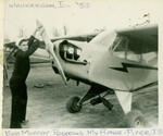 Waukegan, Il, air field, Bob Moffat propping Piper J3 airplane
